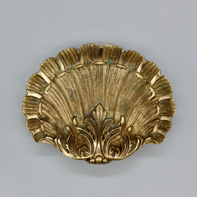 A small footed scallop shell dish, cast with real weight and detail — deep radiating flutes, a scalloped rim, and an...