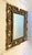 This large Rococo style mirror featuring a carved gilt wood frame with scrollwork decoration has a deeply beveled mirror...