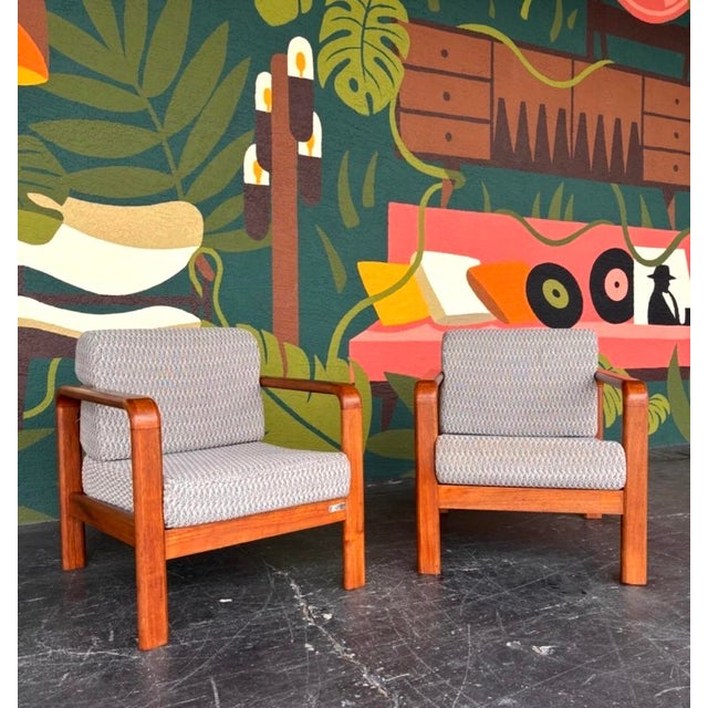 Great profile and comfort on this teak club chair pair. Frames are solid teak with thick upholstered cushions and the back...