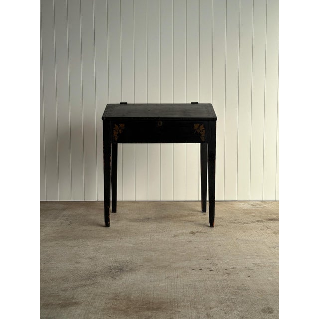 Early American slant-front desk in original black paint with hand-stenciled vine and grape decoration. Hinged writing...