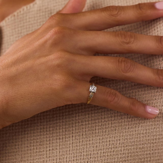 This elegant Art Deco diamond engagement ring is a refined 1930’s design, centered by a transitional brilliant cut diamond...