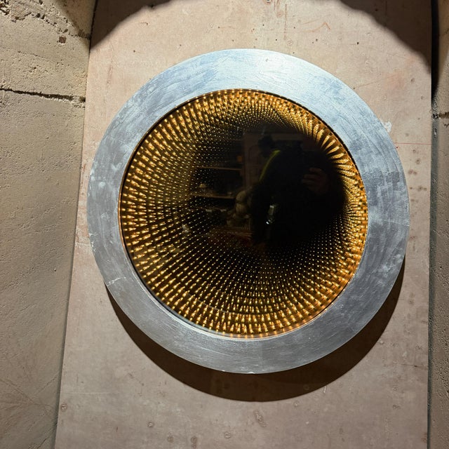 For your consideration, a round infinity wall mirror featuring a textured silver-finished frame and a glowing tunnel of...