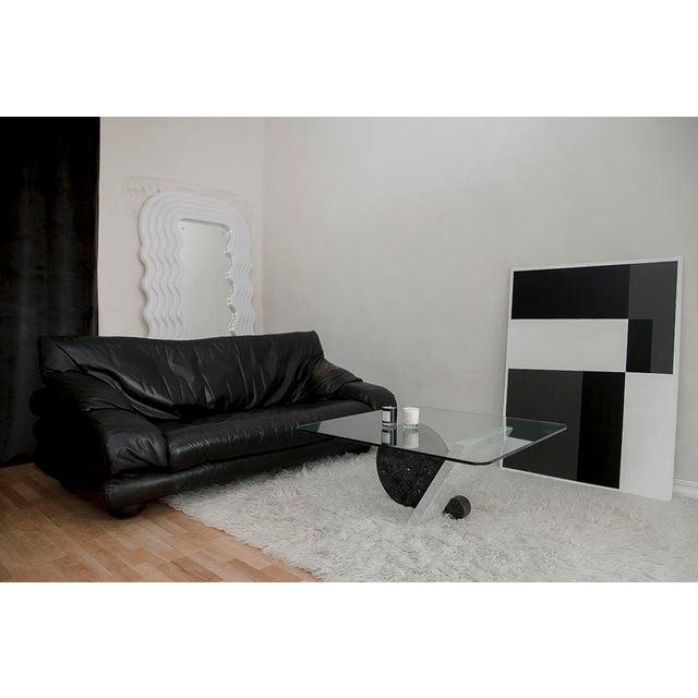 Black leather sofa with a beautiful patina. This modern piece of furniture was characterized by clean lines, shapes, and a...