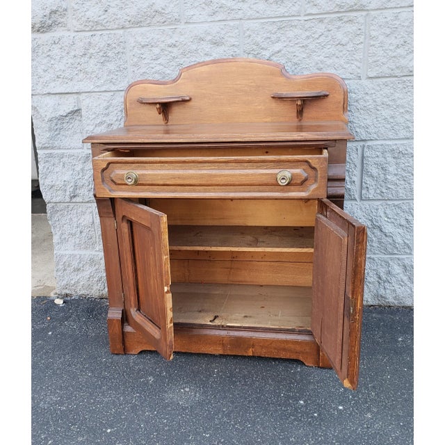 An early 20th century american fruitwood washstand featuring a single large drawer with peg joints,, a lower storage with...