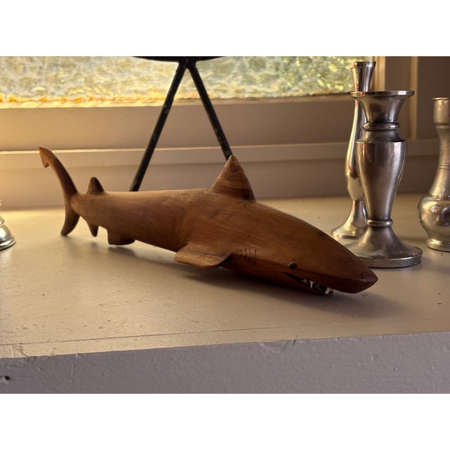 Striking vintage hand-carved wood shark sculpture featuring an elongated streamlined body, prominent dorsal fin, curved...