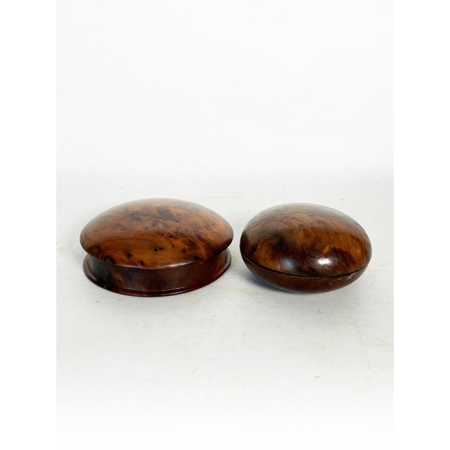 Pair of round wooden boxes, France, 1970s, with a clean, organic design. Made from wood with rich, contrasting grain, they...
