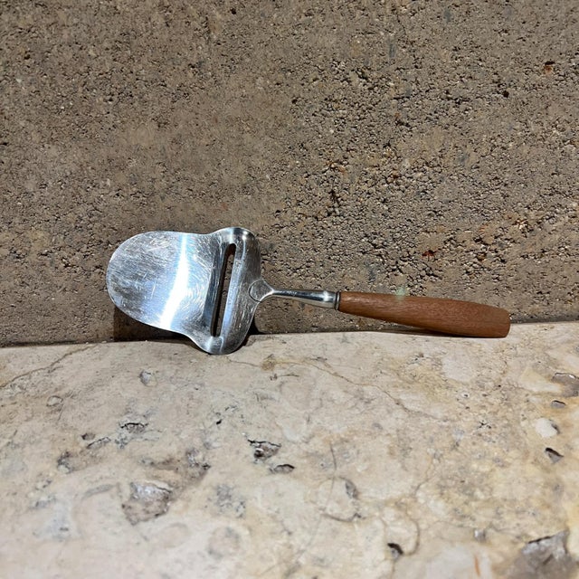 AMBIANIC presents 1960s Scandinavian Sculptural Cheese Slicer Spar Norway made in Norway Stainless steel with teak handle....