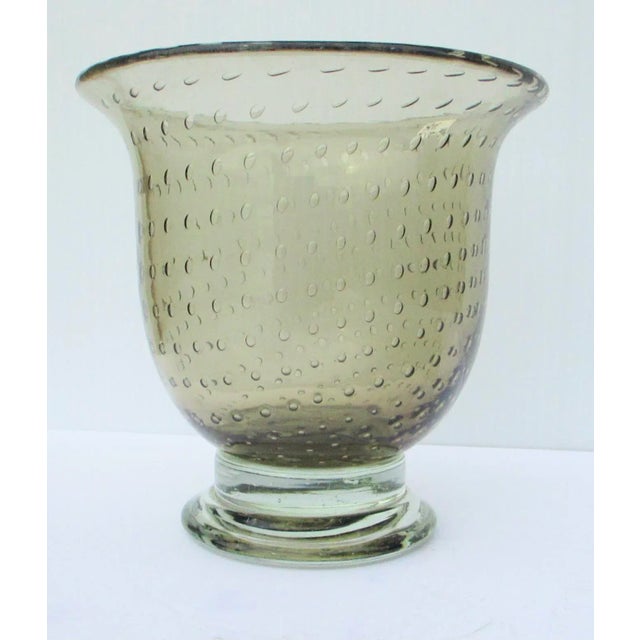 Soft grey art glass with a pattern of glass bubbles around the body. Formed in Roman classical shape, the wide mouth...
