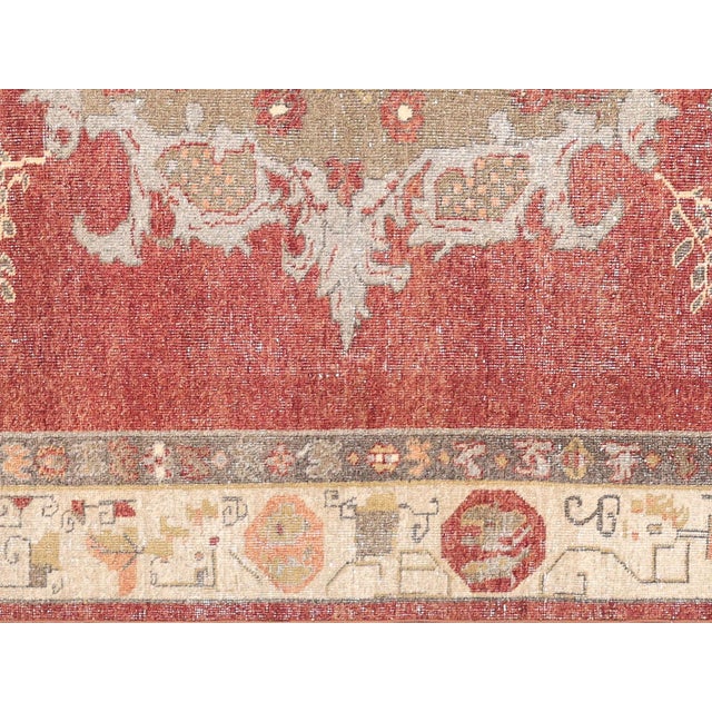 This vintage Turkish Oushak rug, measuring 7'4" x 10'9", is handwoven with wool on a wool foundation in the Oushak region...