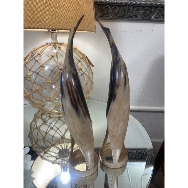 Striking vintage set of two hand-carved bird sculptures crafted from genuine steer horn. These elegant, elongated figures...