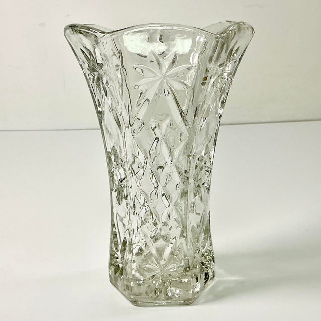 This is a lovely cut glass clear vase featuring starbursts and cross hatching. It has a six-sided shape and flares out at...