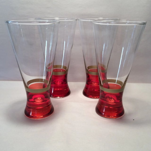 Heavy weighted hand blown vintage pilsner glasses with red base and gold band. Easy to hold in your hand. High end glasses.