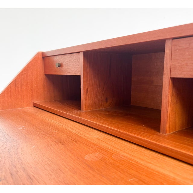 Charming wooden Danish bureau with ample storage space. The bureau has a worktop that can be extended for extra workspace....