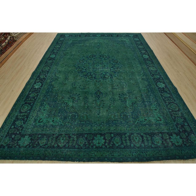 An authentic vintage traditional Overdyed Mashad rug hand-knotted with an all-wool pile on a cotton foundation. This...