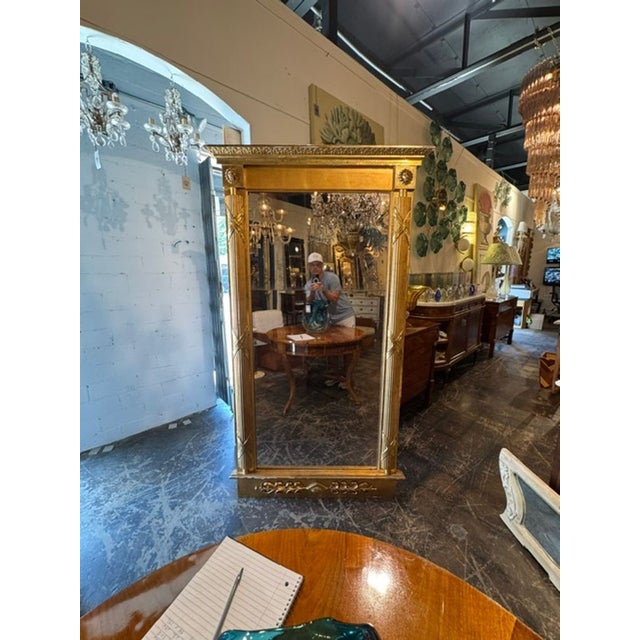 This 19th c. Swedish Neoclassical Giltwood Mirror exudes elegance and sophistication with its intricate design and gold...