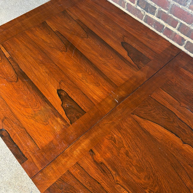 A striking Scandinavian Modern extension dining table featuring a beautifully figured rosewood veneer top with contrasting...