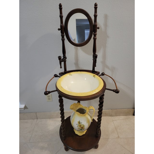 Vintage three legged wash stand with mirror including a ceramic pitcher and bowl decorated with beautiful yellow flowers....