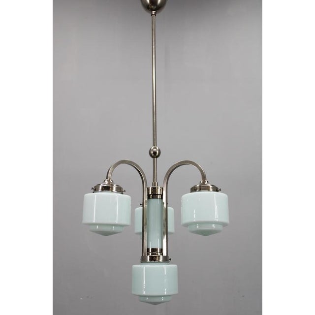 Elegant art deco chandelier, produced in czechoslovakia in the 1930s, constructed from nickel-plated metal and featuring...