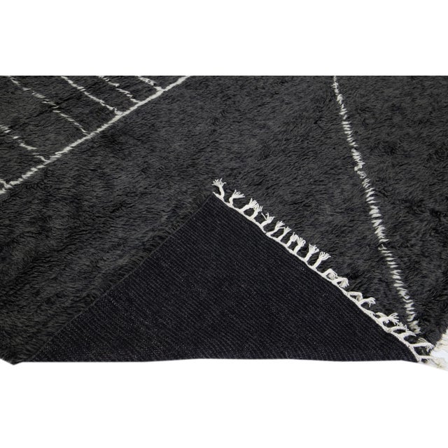 Beautiful modern Moroccan style hand-knotted wool rug with a black field and white fringes in a gorgeous geometric...