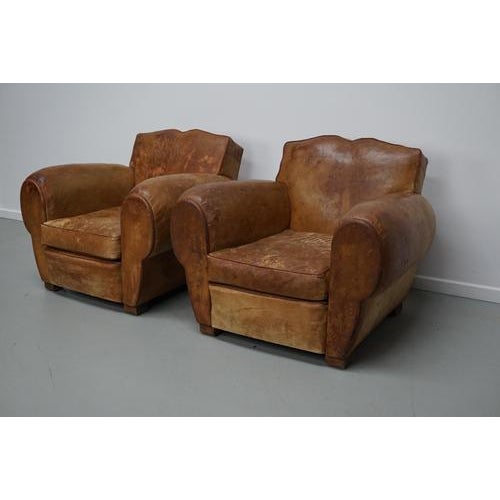 These club chairs were designed and produced in France during the 1940s. The chairs are made from cognac leather held...