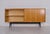 Modernist sideboard with sliding doors, anonymous edition from the 1950s. Doors in figured sycamore maple, black lacquered...
