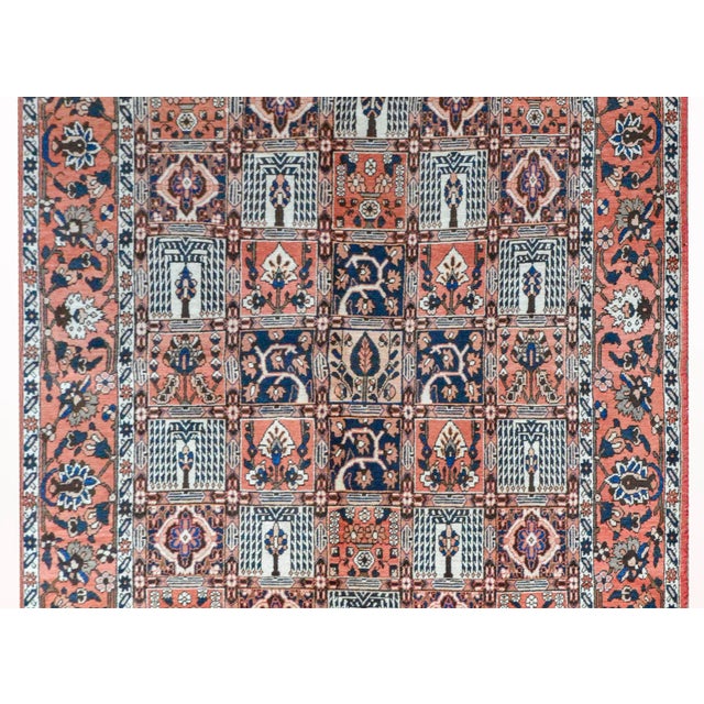 A vintage Persian Bakhtiari rug with a patchwork pattern depicting various trees, trees-of-life, and flowers, surrounded...
