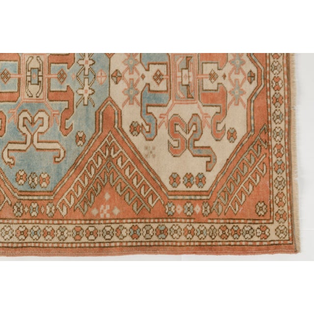 This is a vintage Turkish Oushak rug from the Mid 20th Century. The piece was hand-knotted.