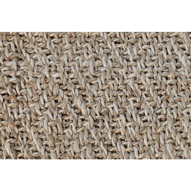 Textural jute woven rug in ivory, beige, and silvery tones. Please note that its appearance may vary depending on lighting...