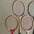 Set of five mismatched 1980s badminton rackets in reds, blues and blacks. Please see condition details noted. Most items...