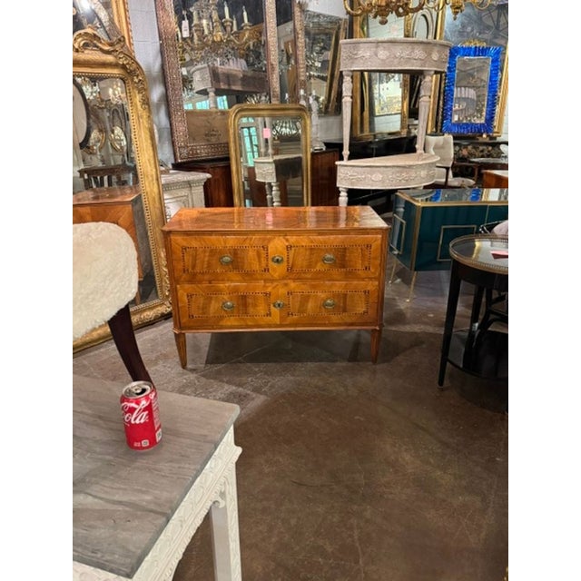 The 18th c. Italian Inlaid Walnut Commode is a stunning piece of antique furniture that exudes elegance and style. Made...