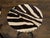 A pair of French iron guéridon side tables from the mid 20th century with round zebra hide tops, twisted bases on three...