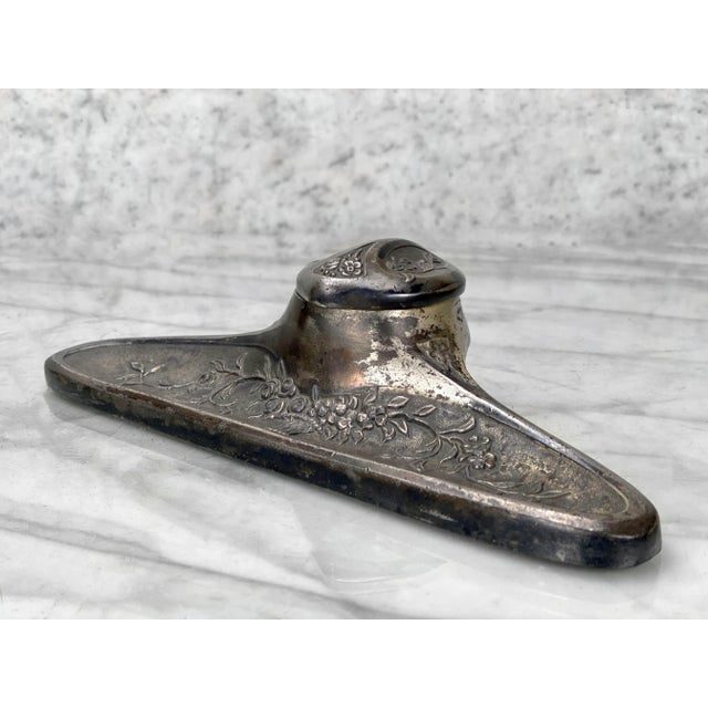 An Art Deco Cast Metal Floral Motif Inkwell with Pen Rest, c. Mid 20th Century. This Inkwell would look exceptional while...