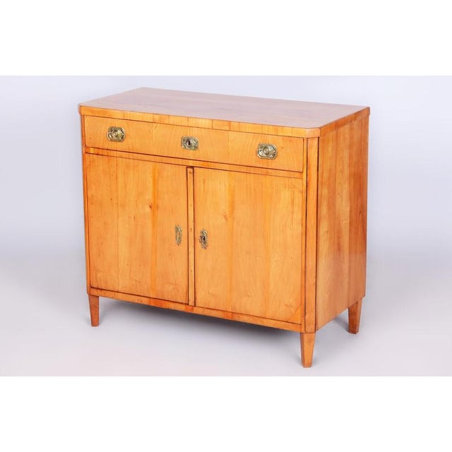 This elegant Biedermeier vertiko / chest of drawers dates back to the early 19th century and was crafted in Bohemia. Its...