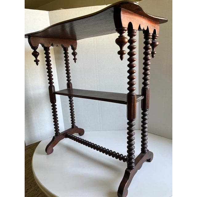This antique Victorian table is very unique featuring the bobbin/spool legs and the four finials typical of the Victorian...