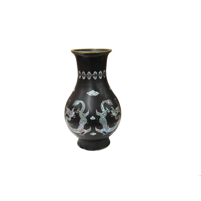 This elegant black metal vase features a bulbous body and a smoothly flared rim framed in a warm brass tone. The dark...