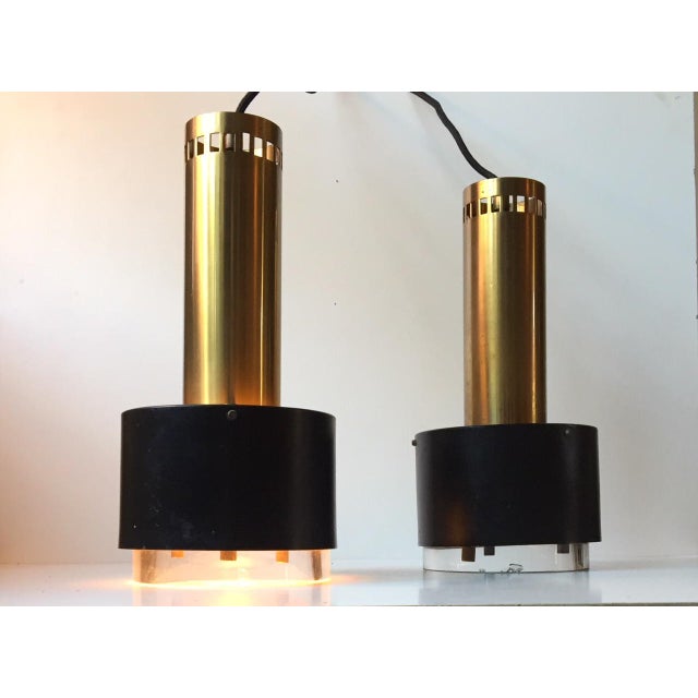 This is a pair heavy pendant lights made from partially lacquered and perforated solid brass and thick Orrefors Crystal....