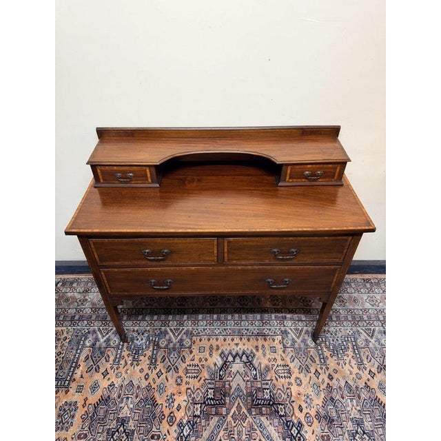 A lovely edwardian mahogany dressing table, featuring elegant inlaid detailing and a classic, well-balanced form. The...