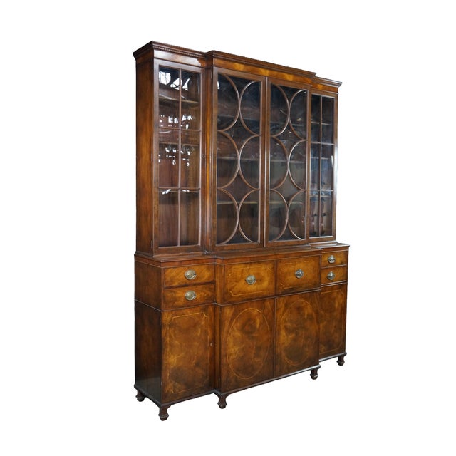 This magnificent mid-century Baker Furniture Georgian style breakfront china cabinet stands as a monumental masterclass in...