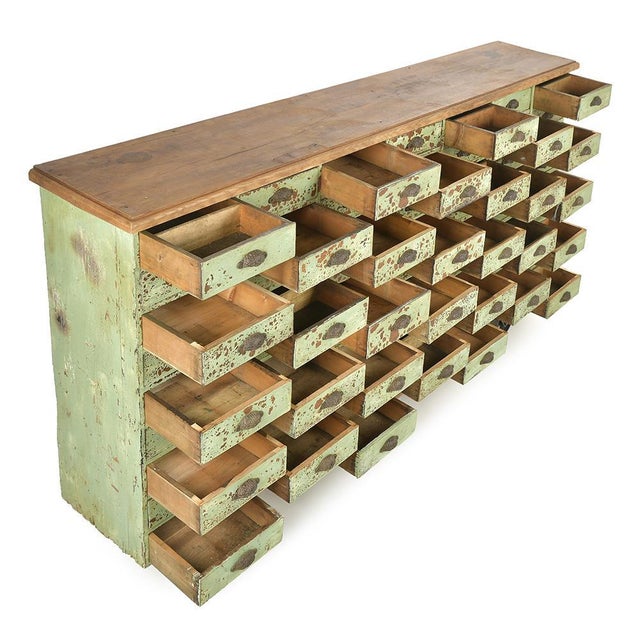 This solid wood workshop cabinet with 63 drawers is attractive due to its green patina and generous proportions. Formerly...