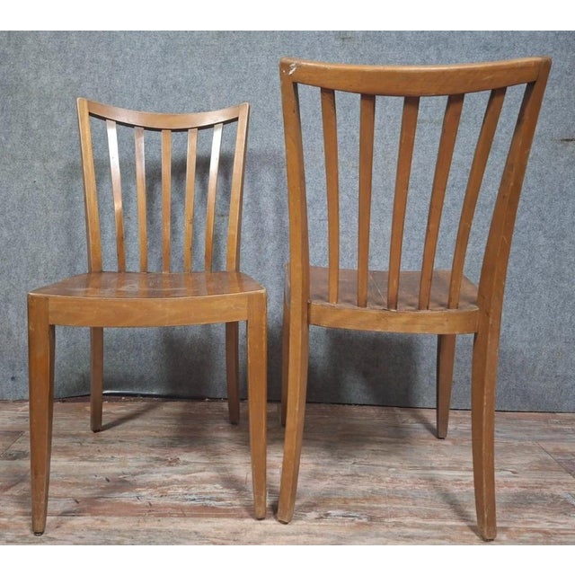 Pair of vintage chairs in light wood, with a simple and elegant design, dating from the 1950s-1960s. They feature a gently...