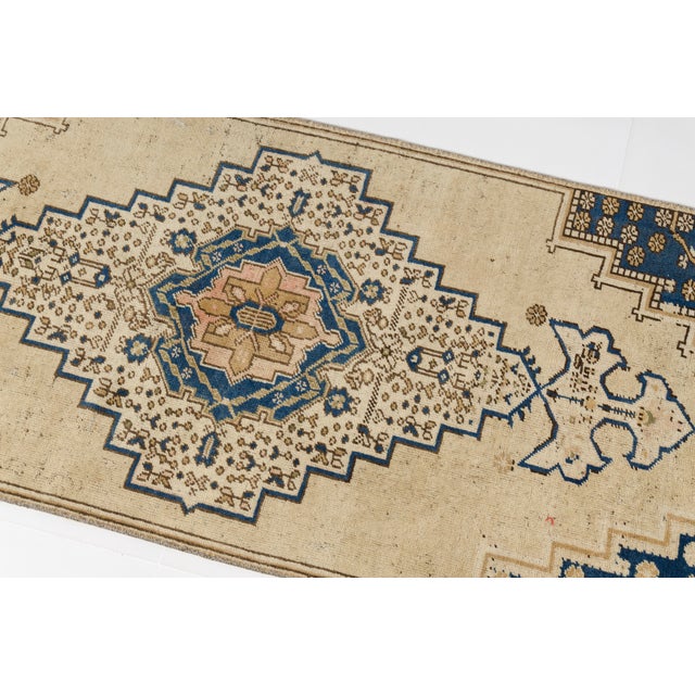 This is a vintage Turkish Oushak rug from the Mid 20th Century. The piece was hand-knotted.