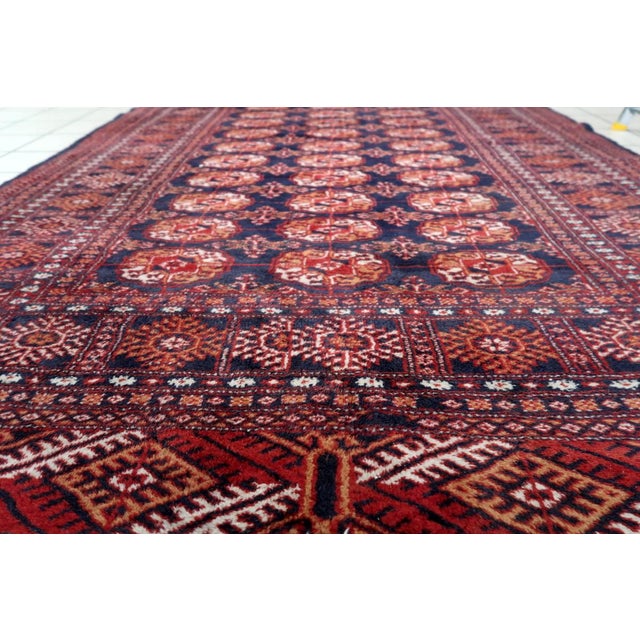 Handmade Vintage Uzbek Bukhara Wool Rug – 1960s – 5' x 8.3' Tribal Carpet Add a touch of Central Asian heritage to your...