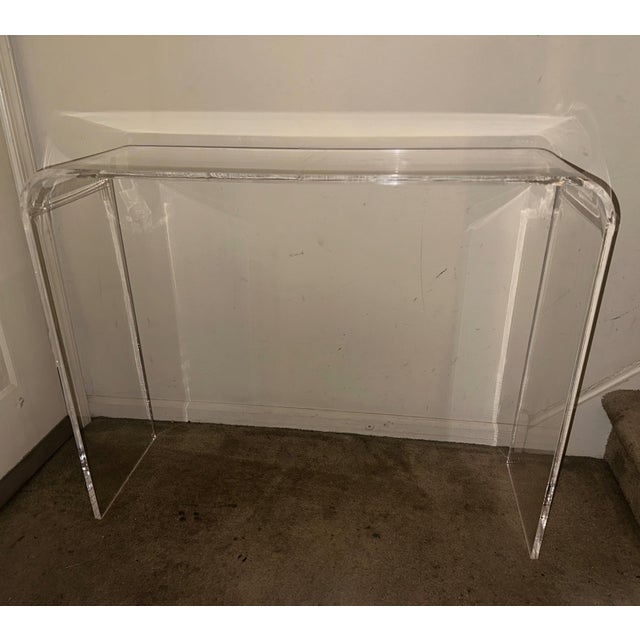 Executed in a single continuous sheet of thick optical-grade acrylic, this waterfall console table represents the apex of...