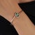 Crafted in 925 sterling silver, this elegant open cuff bangle features 9.12 carats of natural emerald-cut emeralds,...