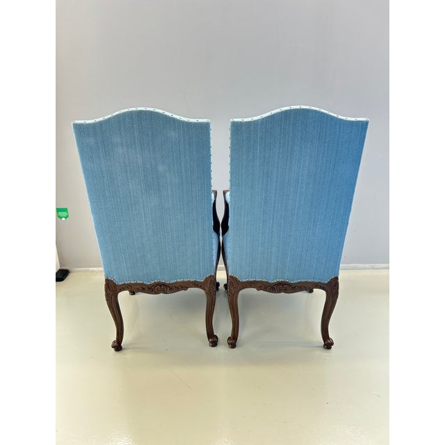Carved wooden headboard chair with floral decoration. It has blue upholstery. Both the upholstery and the wood are in...