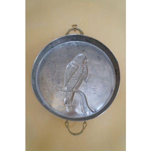 A large vintage decorative copper mold featuring a raised falcon on a branch in relief. The round form, warm copper...