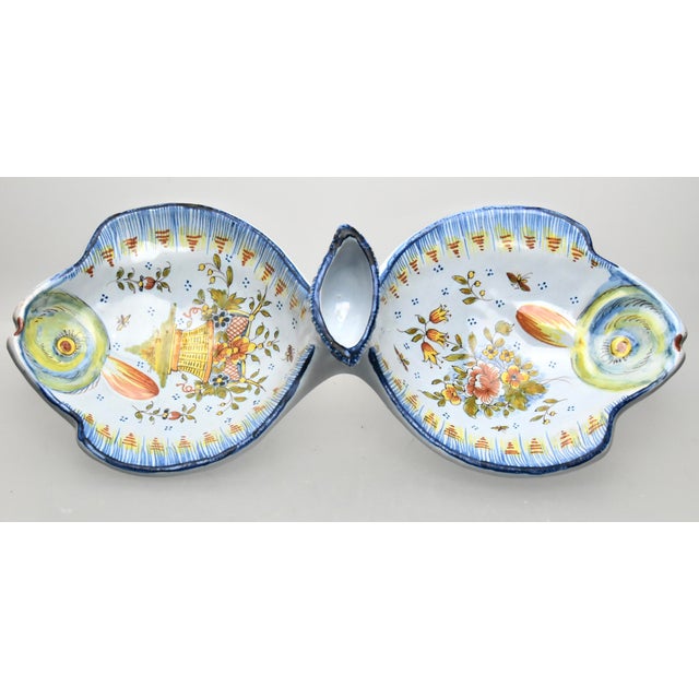 A late 19th century hand painted faience serving dish, having a whimsical shape of two flounders with floral and beehive...