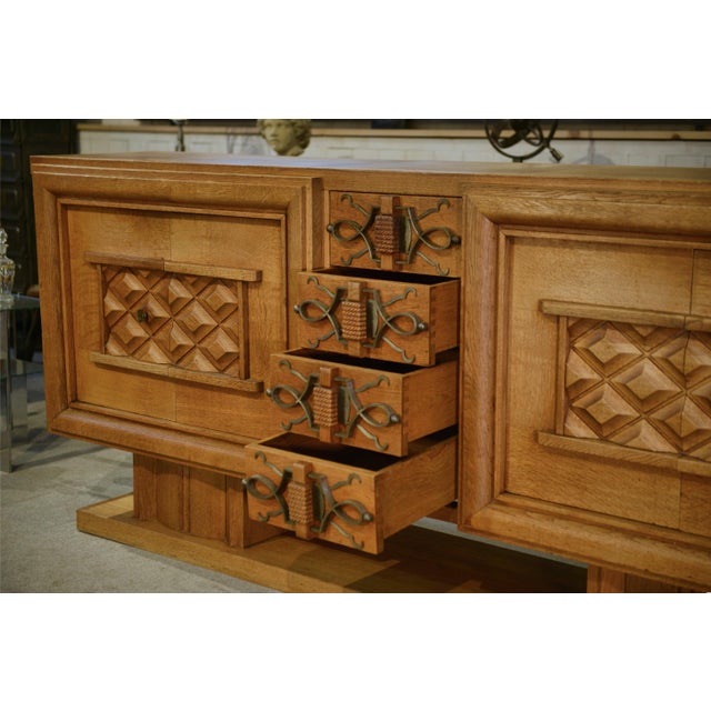 Large oak sideboard in a powerful style, typical of French production from the 1940s. The fronts are enlivened by panels...