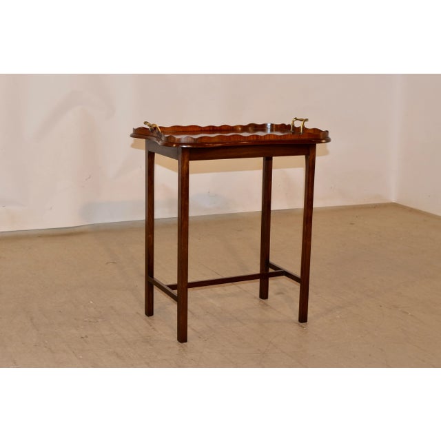 19th century mahogany shaped serving tray with serpentine and inlaid molded gallery and bulbous brass handles. The tray...