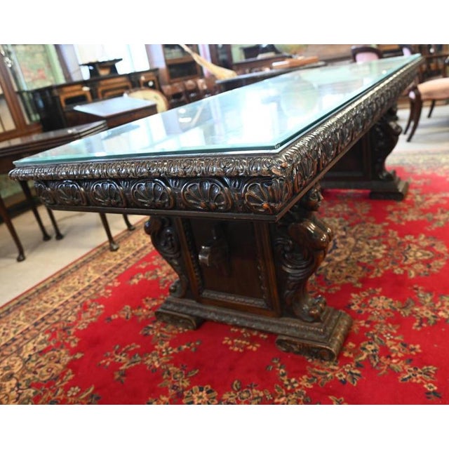 Large Italian carved walnut dining / centre table with a generous carved freeze all around bases fronted by carved figures...